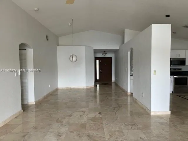 an empty room with a window and a ceiling fan