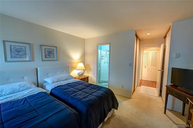 a bedroom with two beds and a flat screen tv