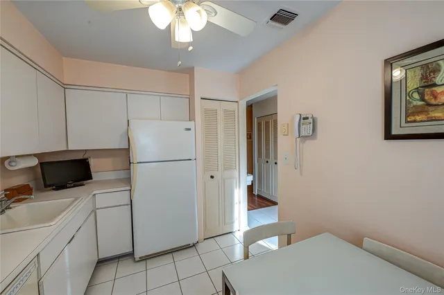 a kitchen with a refrigerator a stove top oven and cabinets