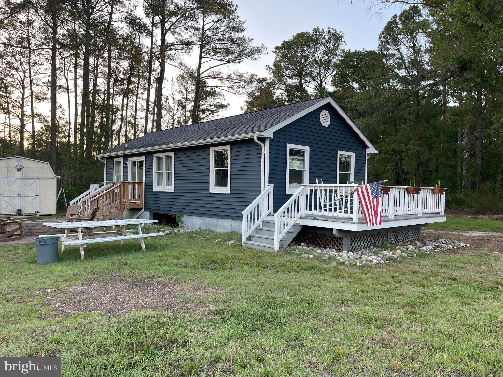 Charming blue cottage in serene woods.