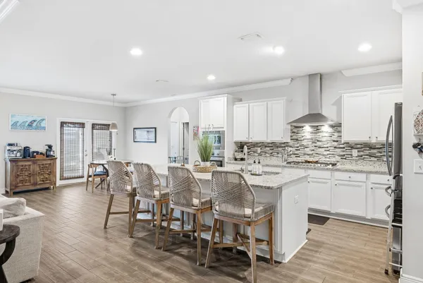 a kitchen with stainless steel appliances granite countertop refrigerator oven cabinets dining table and chairs