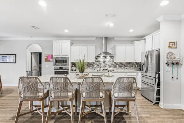 a kitchen with stainless steel appliances kitchen island granite countertop a dining table chairs and granite counter tops
