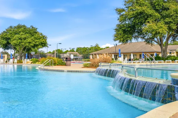 a view of a fountain with a big house in the background