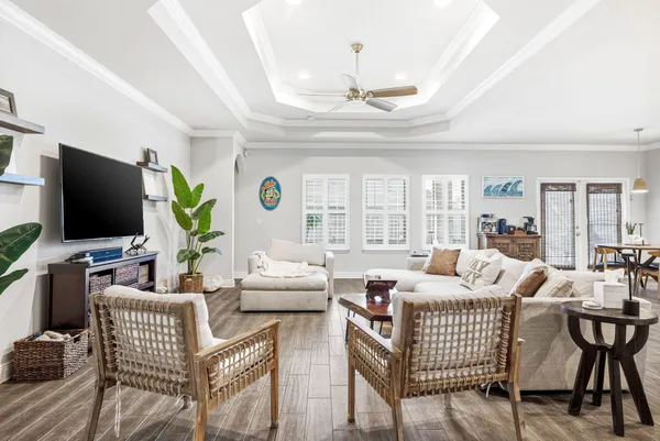 a living room with furniture a flat screen tv and a chandelier