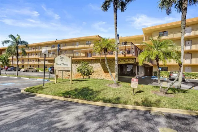 a front view of a house with a garden and lake view