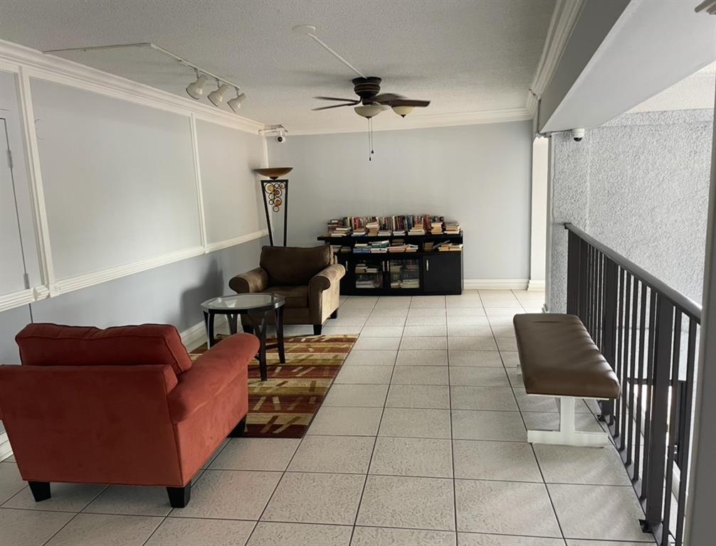 9273 Southwest 8th Street, Unit 117 Boca Raton, FL 33428 - Photo 3 of 7 a living room with furniture and a chandelier