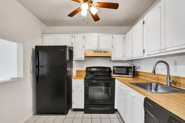 a kitchen with stainless steel appliances granite countertop a refrigerator a sink dishwasher a stove and white cabinets