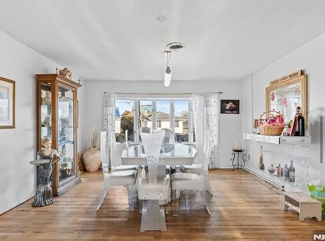 a living room with furniture large window and wooden floor