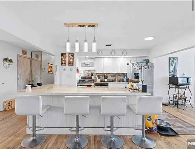 a living room with stainless steel appliances kitchen island granite countertop furniture and a kitchen view