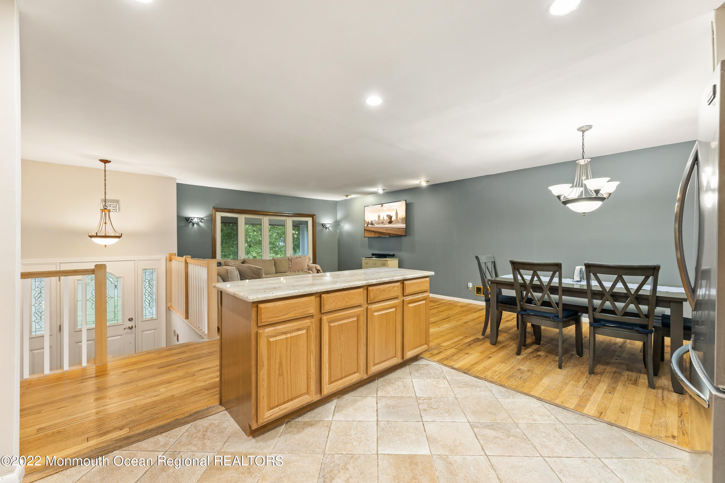 21 Holiday Road Manalapan, NJ 07726 - Photo 17 of 30 a dining hall with stainless steel appliances kitchen island granite countertop a dining table chairs and chandelier