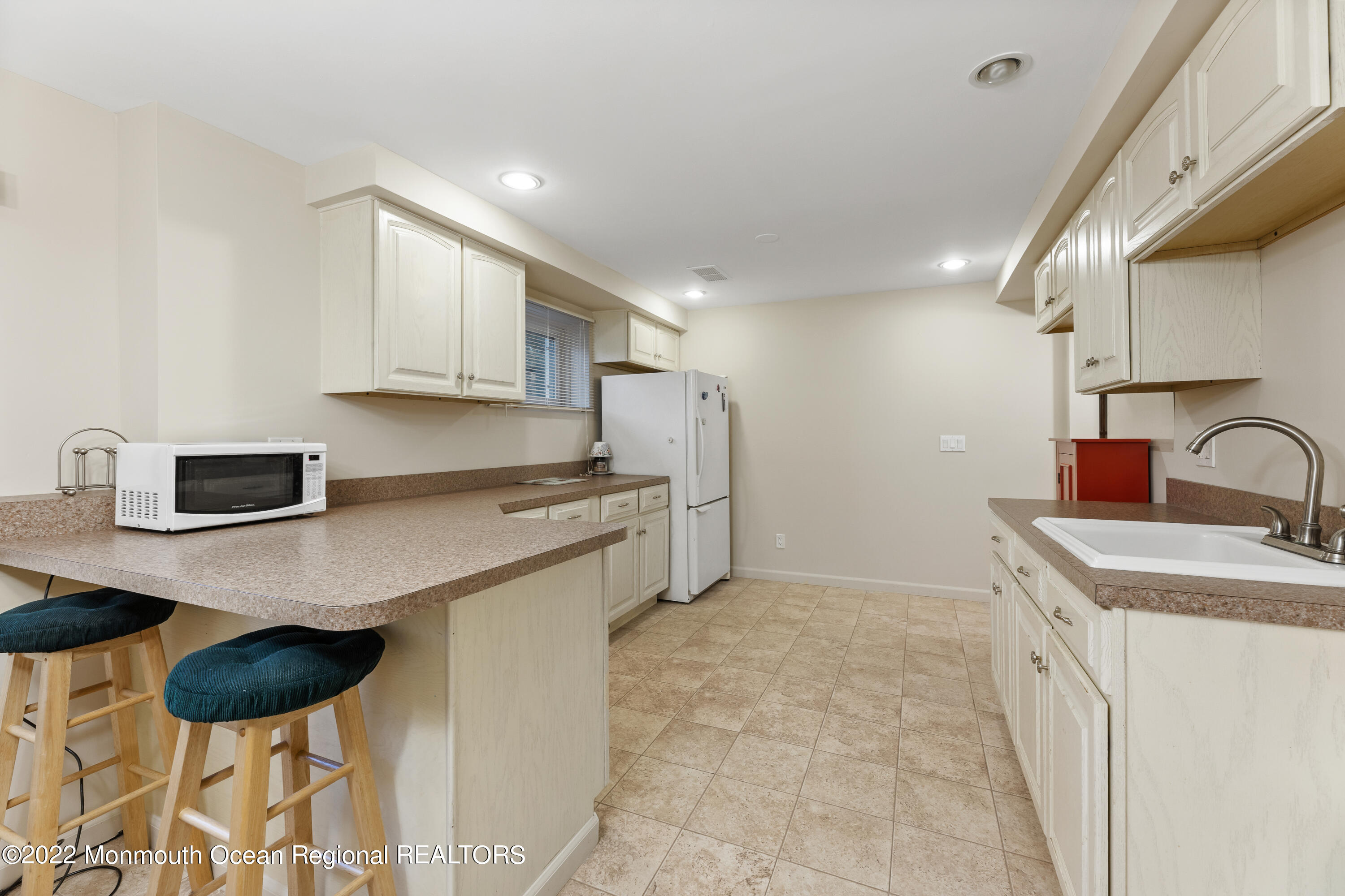21 Holiday Road Manalapan, NJ 07726 - Photo 29 of 30 a kitchen with stainless steel appliances a sink a stove a refrigerator cabinets and a dining table