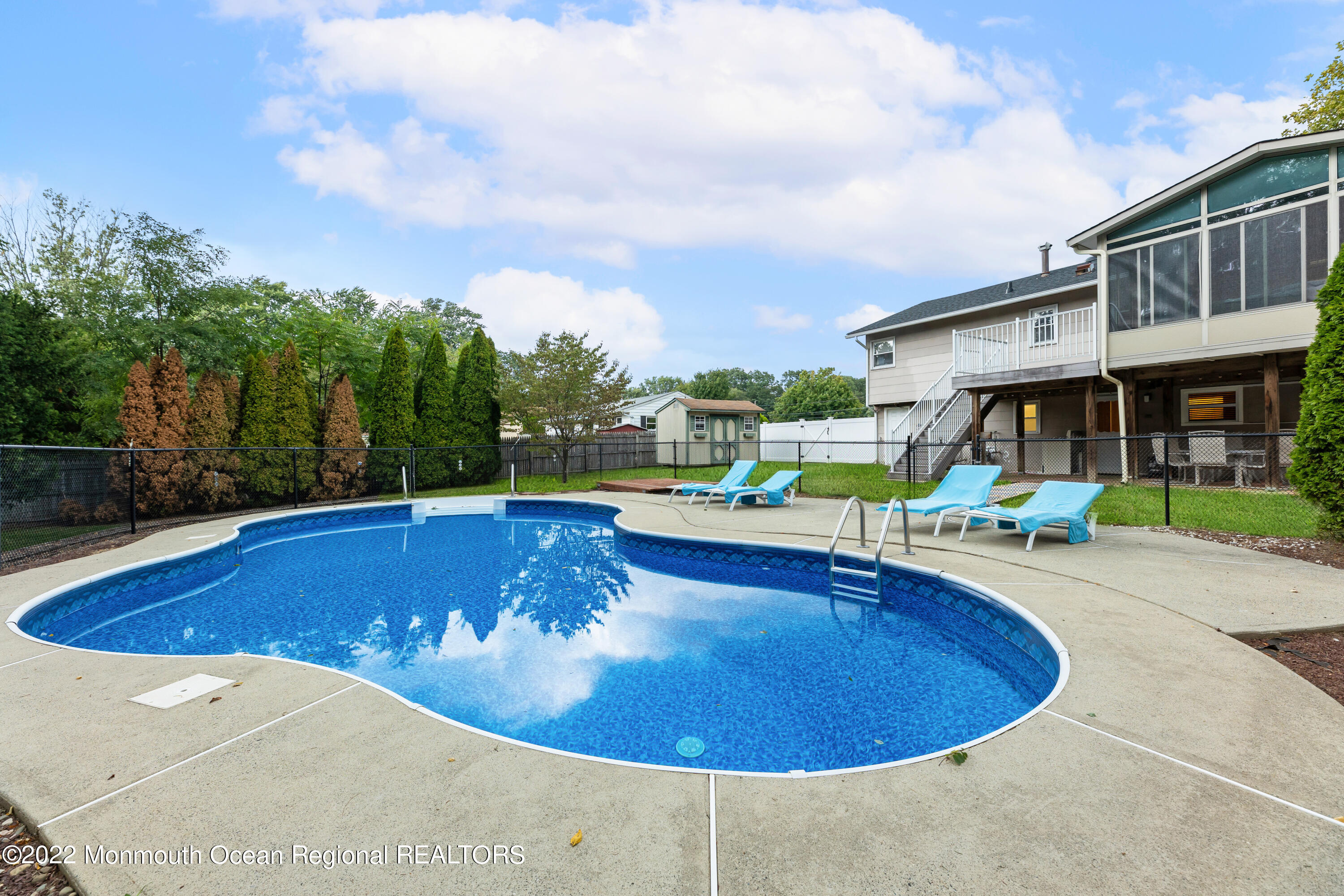21 Holiday Road Manalapan, NJ 07726 - Photo 5 of 30 a view of a swimming pool with a patio