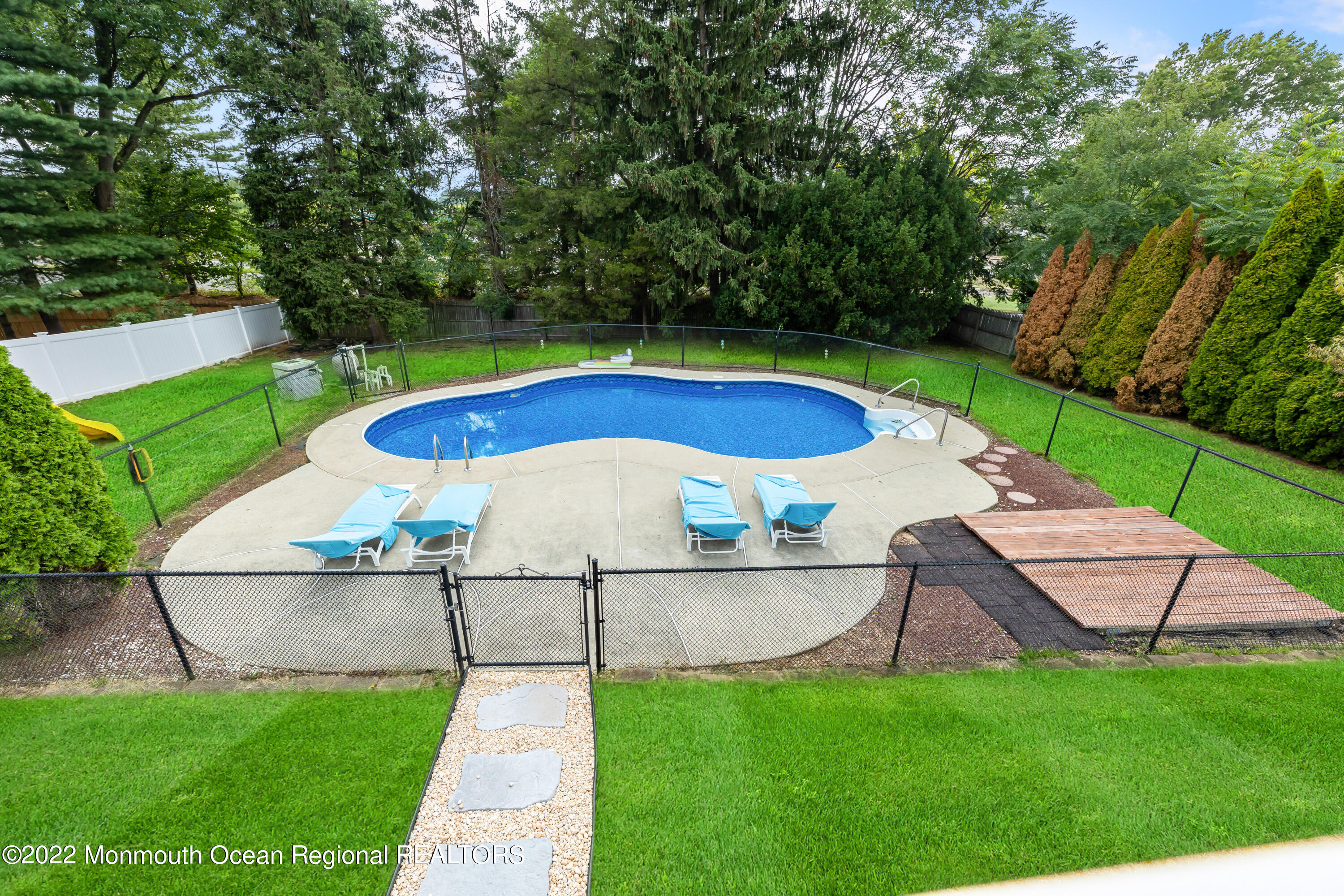 21 Holiday Road Manalapan, NJ 07726 - Photo 7 of 30 a view of a backyard with swimming pool