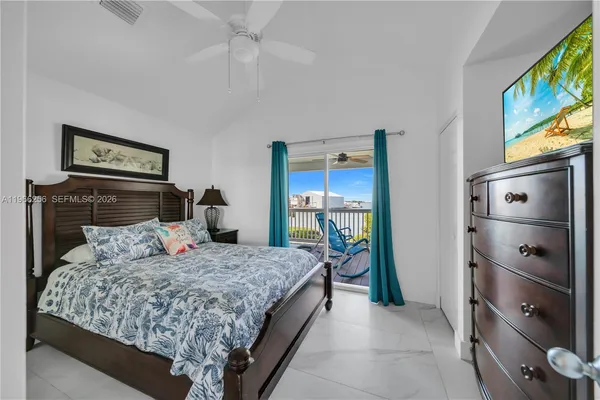 a bedroom with a bed and a flat tv screen on dresser