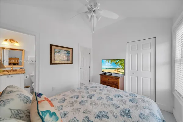 a bedroom with a bed and a flat screen tv