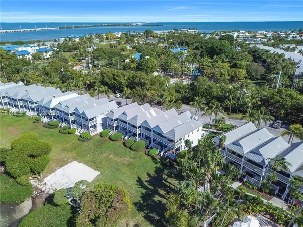 an aerial view of a house with a garden and lake view