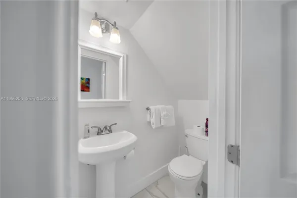 a bathroom with a toilet sink and mirror