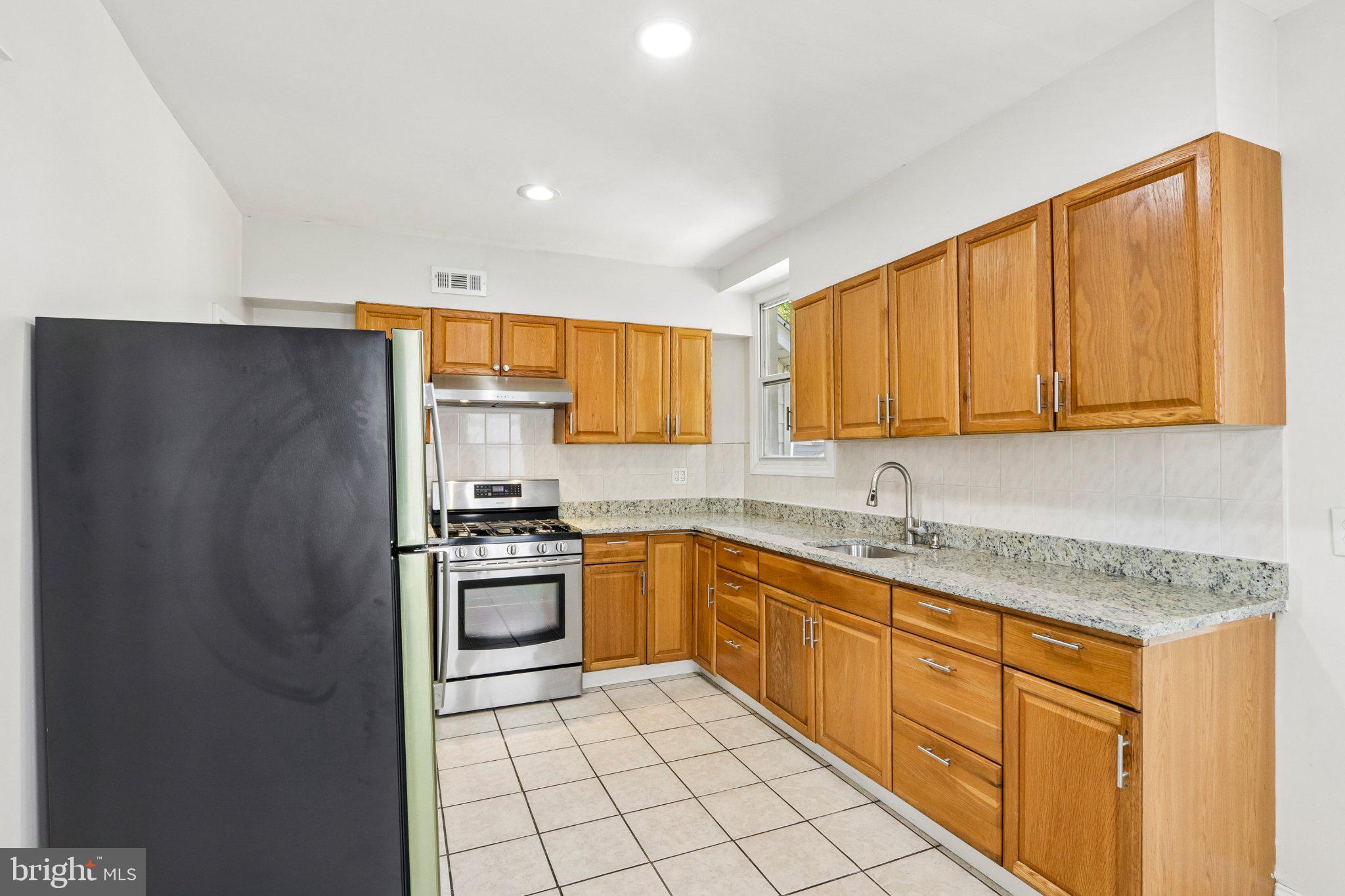 7407 Rogers Avenue Upper Darby, PA 19082 - Photo 13 of 50 a kitchen with stainless steel appliances granite countertop a refrigerator sink and cabinets