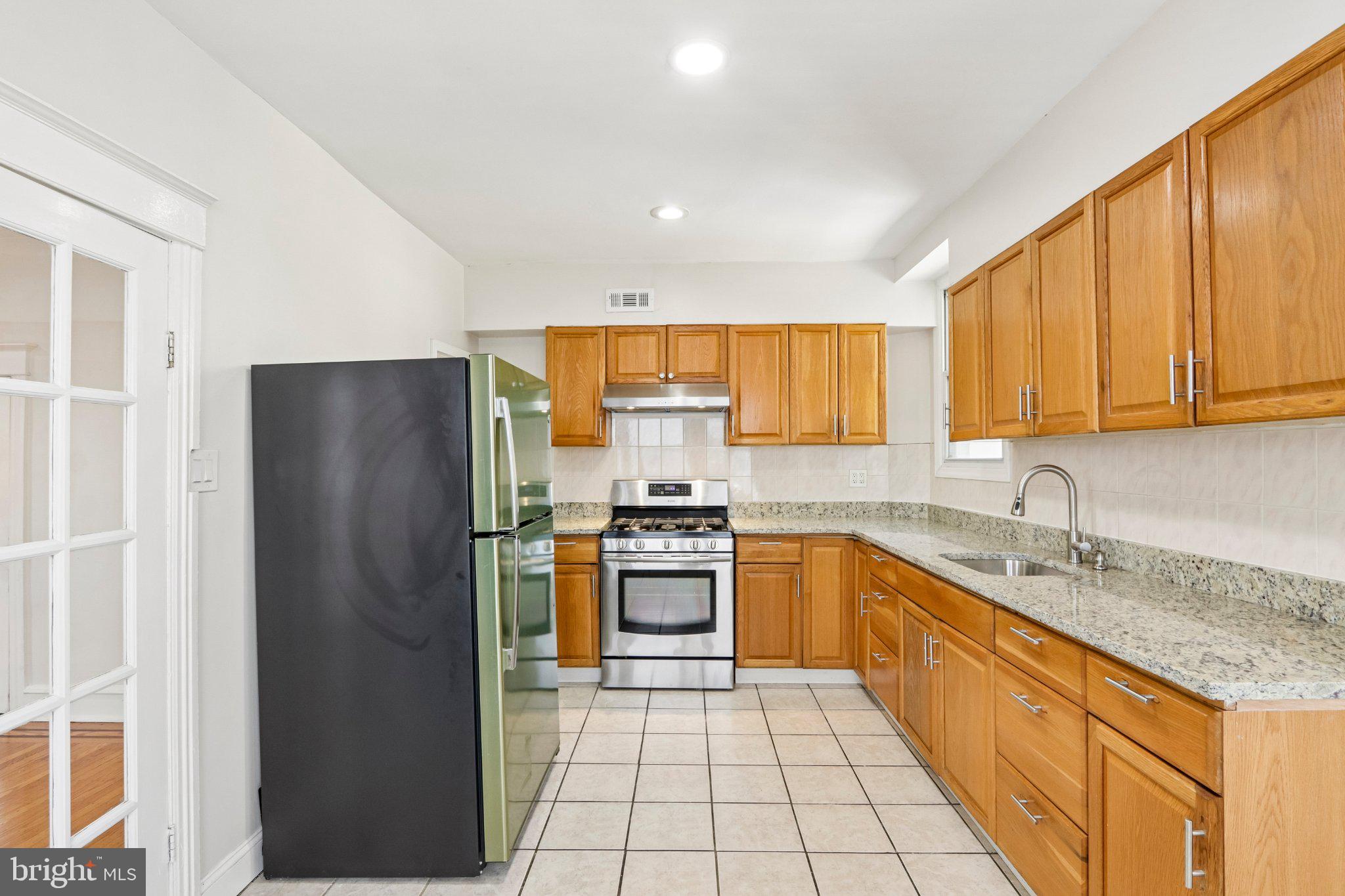 7407 Rogers Avenue Upper Darby, PA 19082 - Photo 14 of 50 a kitchen with stainless steel appliances granite countertop a refrigerator sink and stove
