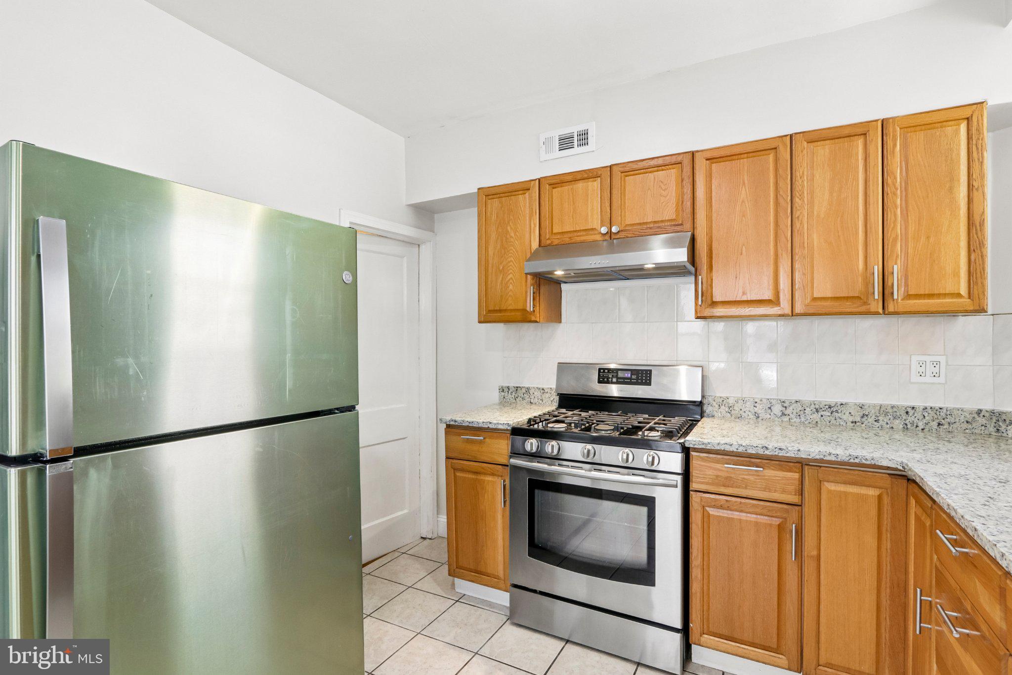 7407 Rogers Avenue Upper Darby, PA 19082 - Photo 17 of 50 a kitchen with stainless steel appliances granite countertop a refrigerator a stove a sink and dishwasher