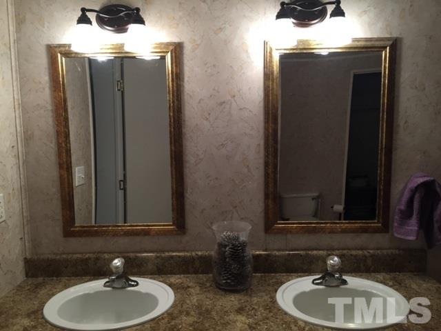 210 Enos Slaughter Road Roxboro, NC 27574 - Photo 8 of 15 a bathroom with a sink and a mirror