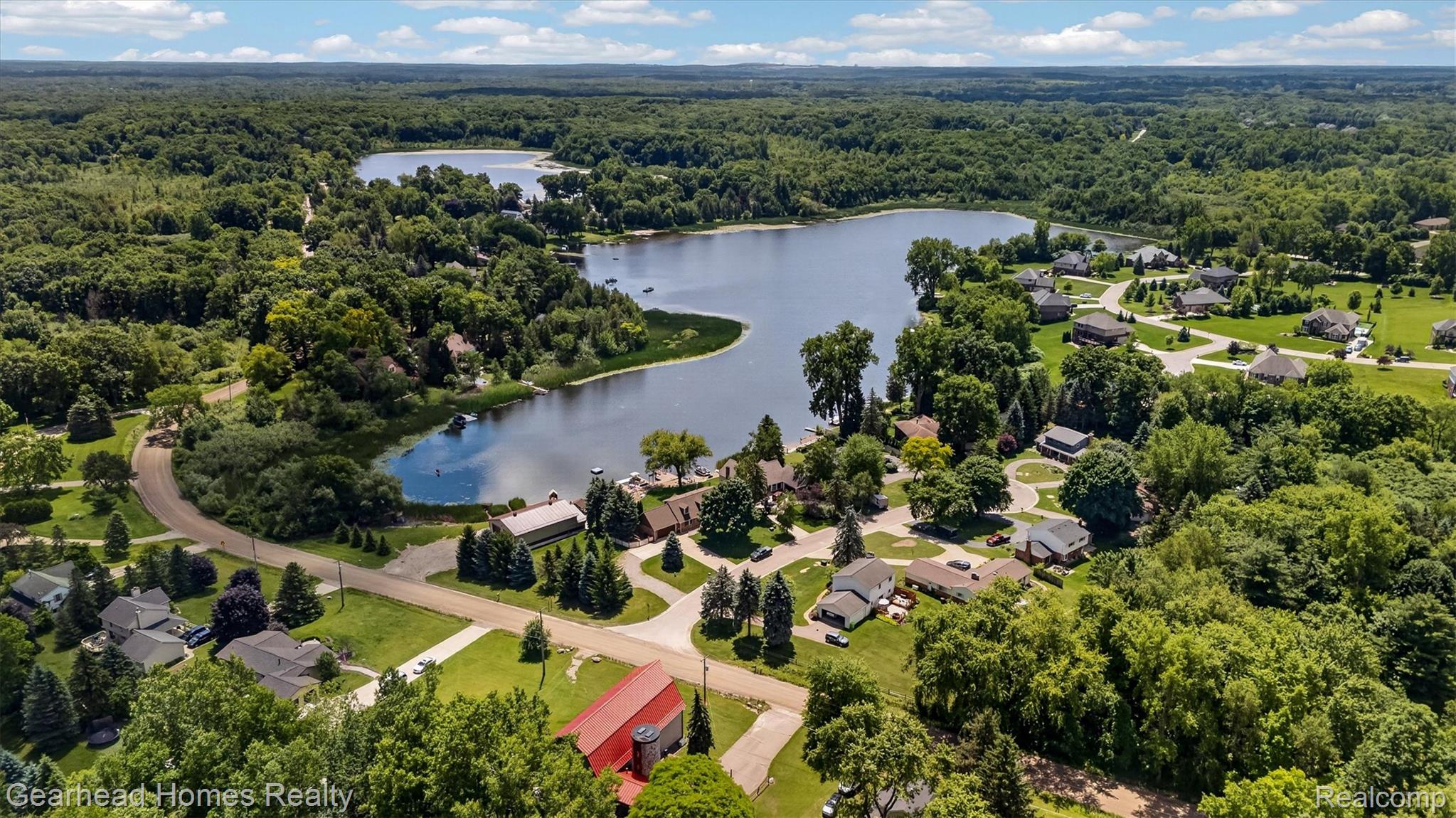 3486 West Drahner Road Oxford, MI 48371 - Photo 45 of 51 Aerial perspective showcasing a community with extensive tree coverage and a prominent lake feature
