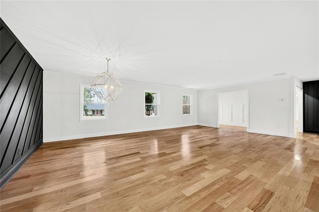3365 Ardley Road Southwest Atlanta, GA 30311 - Photo 12 of 34 an empty room with wooden floor and chandelier
