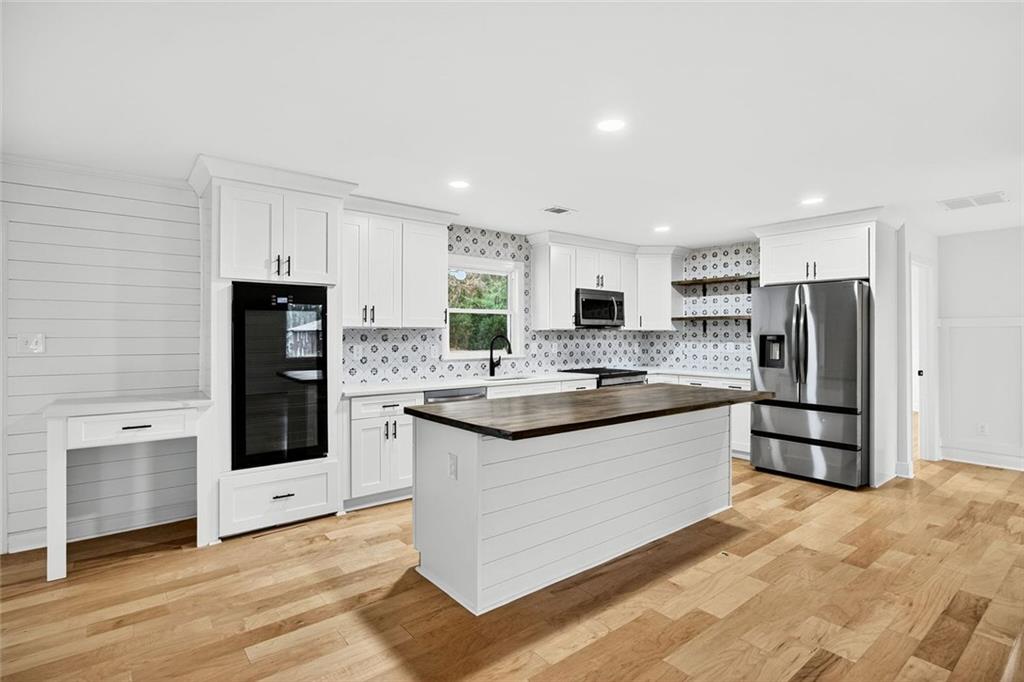 3365 Ardley Road Southwest Atlanta, GA 30311 - Photo 6 of 34 a kitchen with stainless steel appliances kitchen island granite countertop a refrigerator and a stove top oven