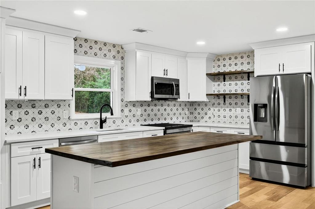 3365 Ardley Road Southwest Atlanta, GA 30311 - Photo 7 of 34 a kitchen with stainless steel appliances granite countertop a sink stove and refrigerator