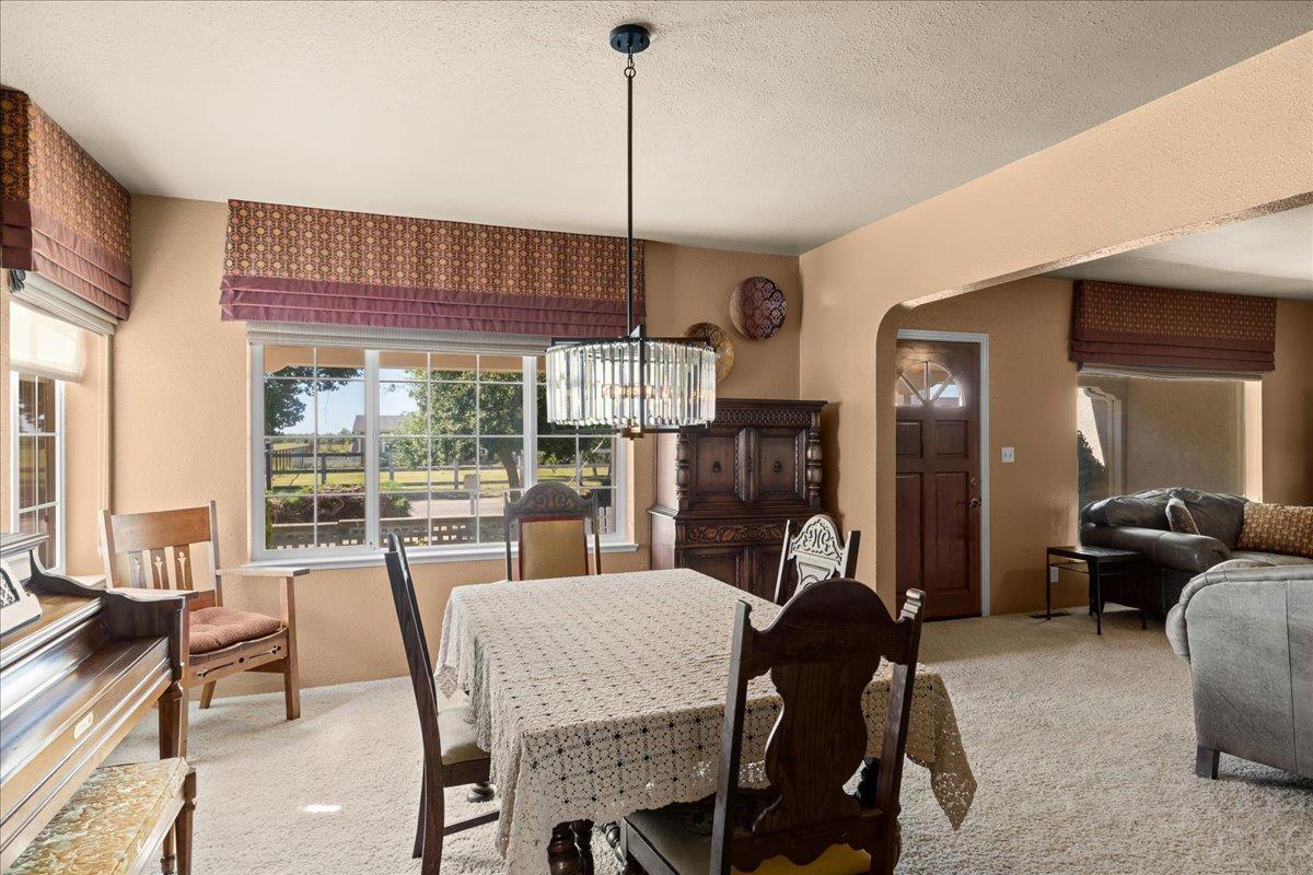 4701 Lone Tree Road Valley Home, CA 95361 - Photo 16 of 59 a dining room with furniture a chandelier and window