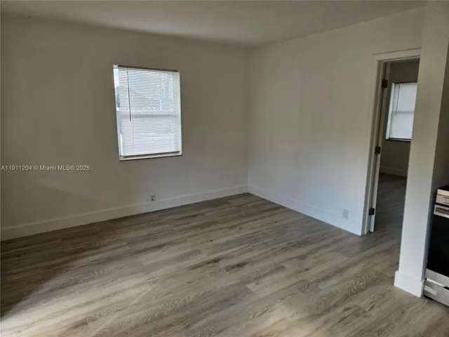 an empty room with wooden floor and a window