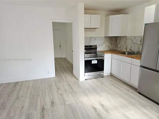 a kitchen with wooden floors and white appliances