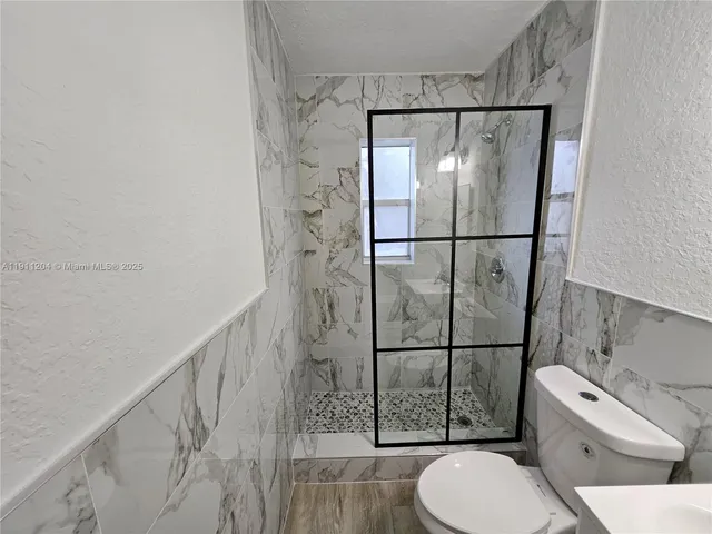 a bathroom with a toilet and a shower