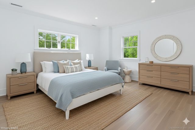 a bedroom with a bed and a dresser next to a window