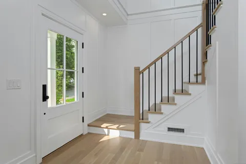a view of an entryway with wooden floor and door
