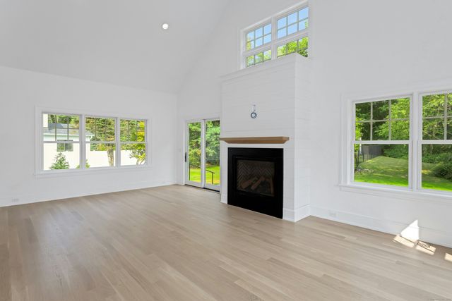an empty room with windows and fireplace