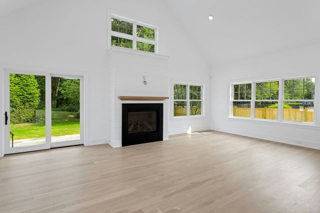 an empty room with windows and fireplace