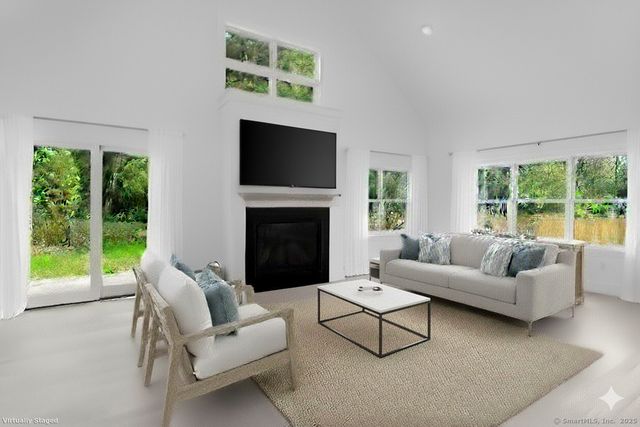 a living room with furniture a large window and a fireplace