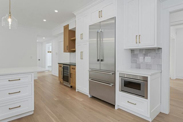 a kitchen with white cabinets and stainless steel appliances