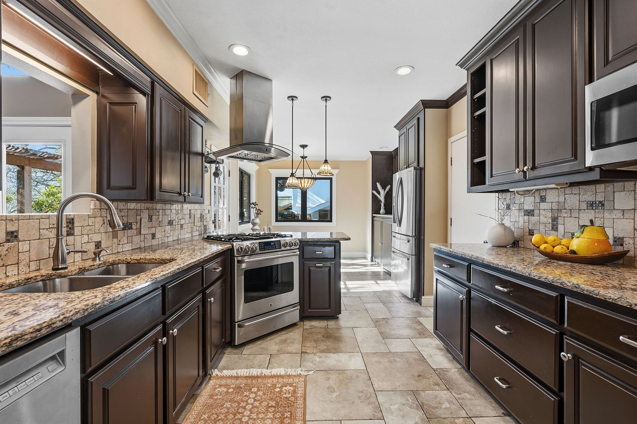 4601 Creek Ridge Austin, TX 78735 - Photo 11 of 40 Kitchen featuring decorative backsplash, dark wood finish cabinets, and crown molding