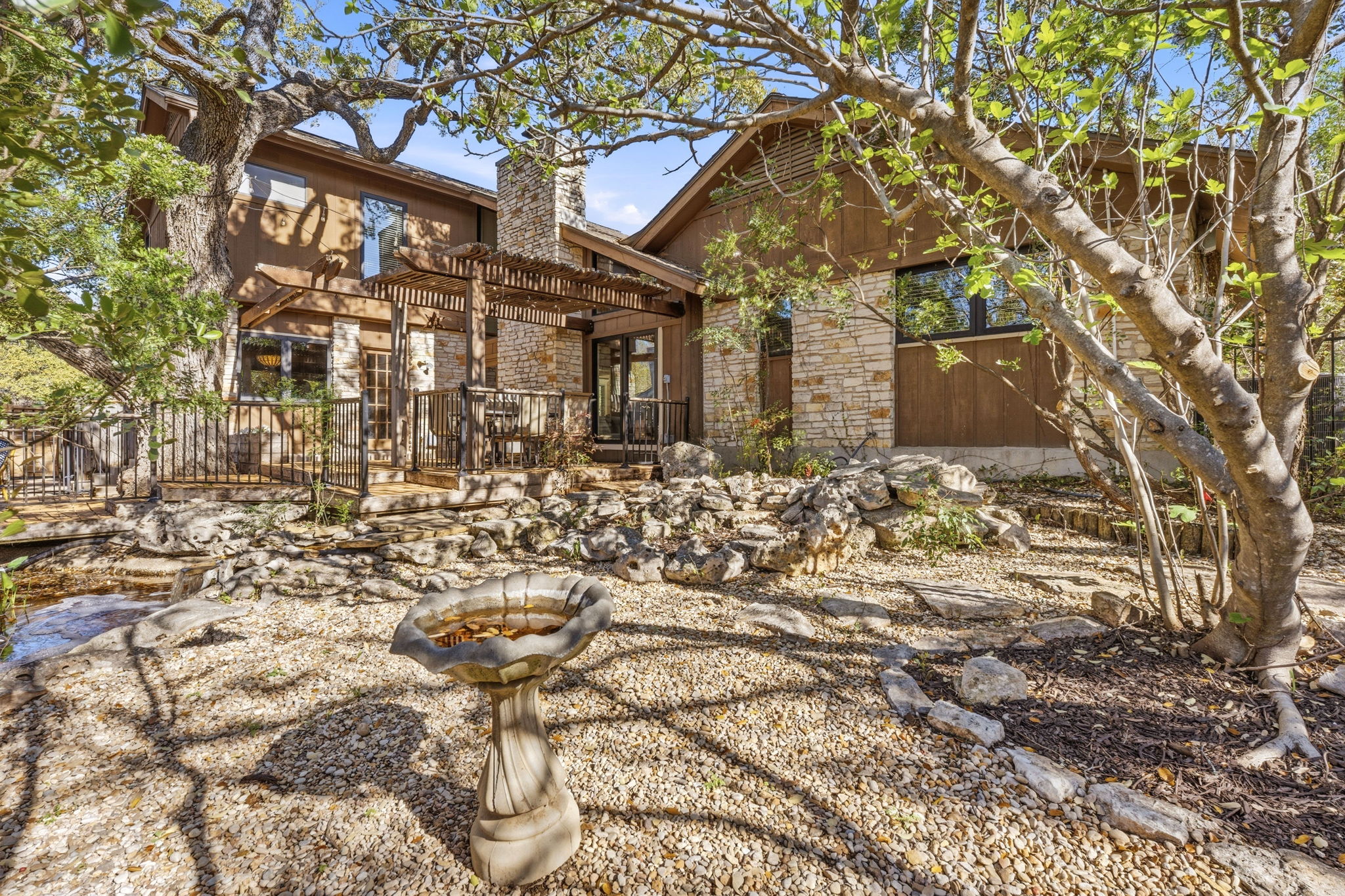4601 Creek Ridge Austin, TX 78735 - Photo 27 of 40 Back of house with a chimney, a pergola, a patio, and stone siding