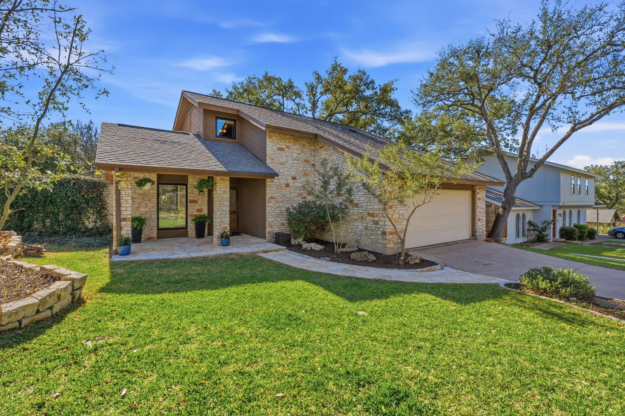 4601 Creek Ridge Austin, TX 78735 - Photo 4 of 40 Mid-century inspired home with a front yard, a shingled roof, driveway, and an attached garage