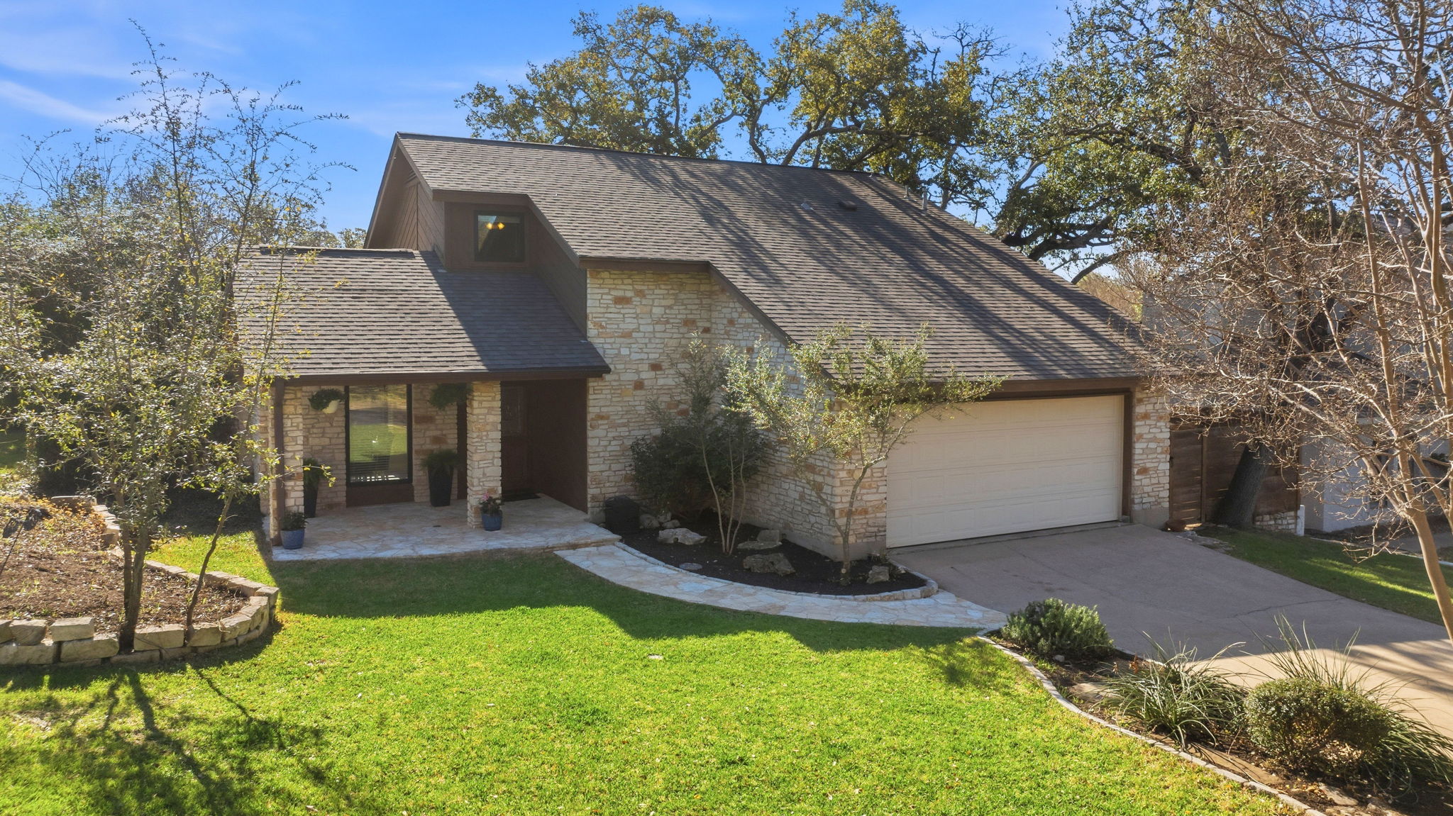 4601 Creek Ridge Austin, TX 78735 - Photo 5 of 40 View of front facade with a shingled roof, a front yard, driveway, a patio, and an attached garage