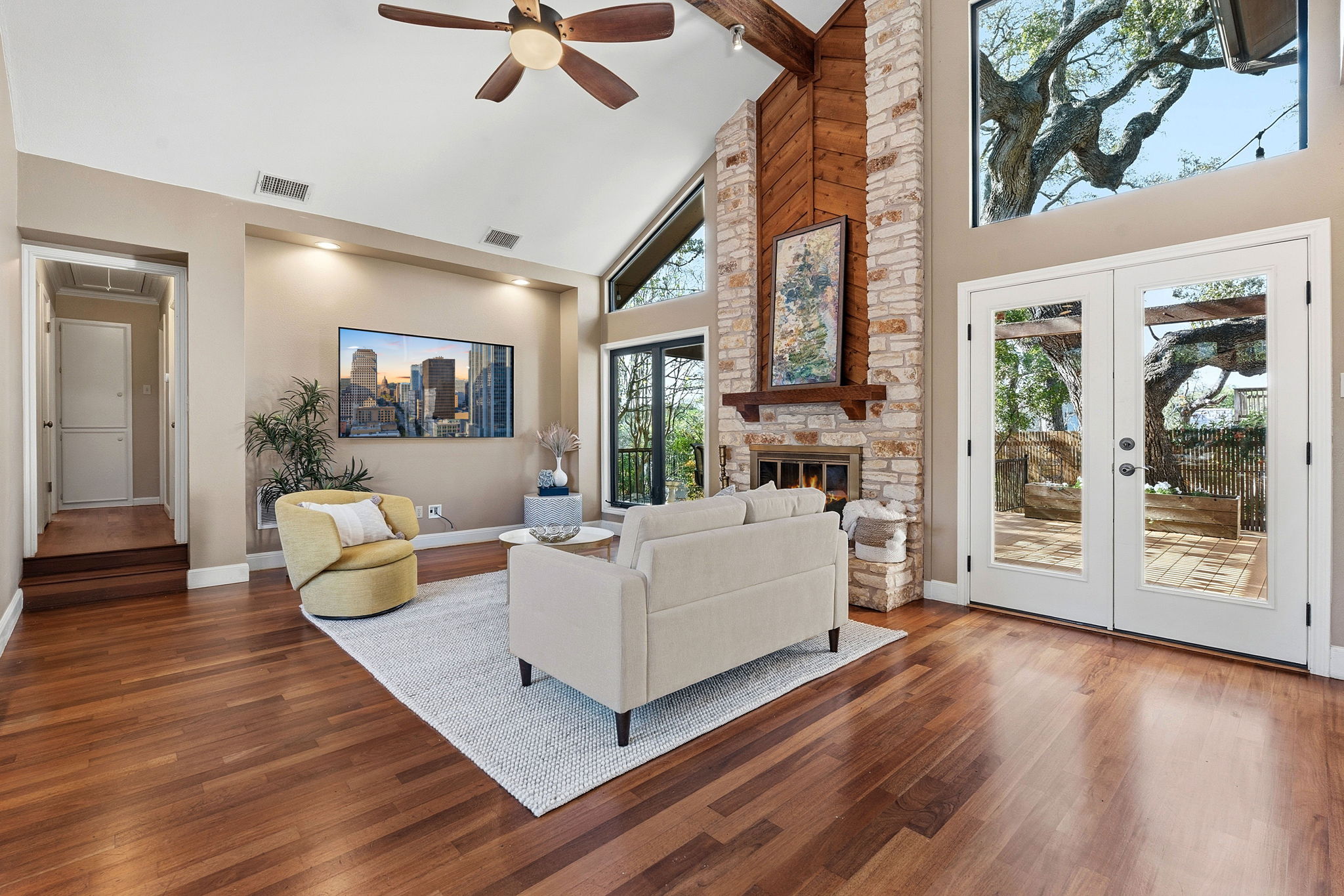 4601 Creek Ridge Austin, TX 78735 - Photo 9 of 40 Living room featuring vaulted ceiling, french doors, wood finished floors, ceiling fan, and a stone fireplace