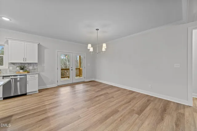 a view of an empty room with wooden floor fireplace and a window