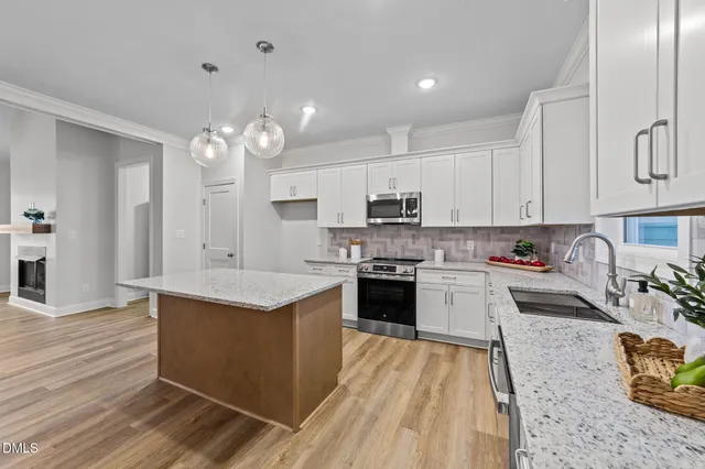 a kitchen with a sink dishwasher a stove top oven a counter space and cabinets