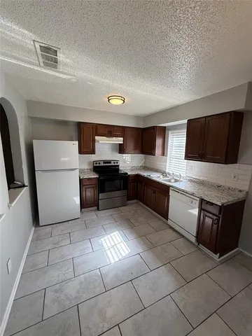 a large kitchen with a stove a microwave and a refrigerator