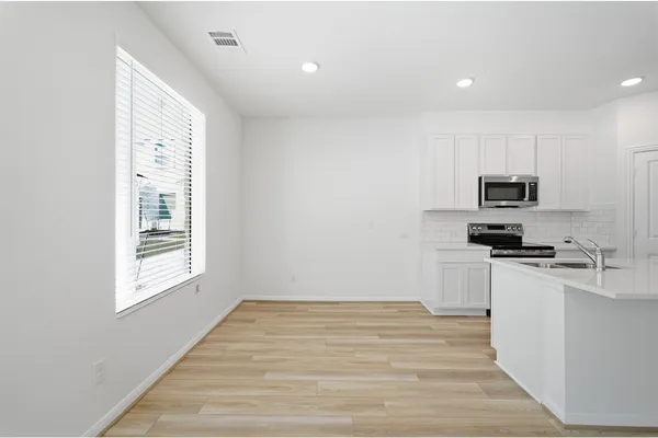 a kitchen with a refrigerator and a stove top oven