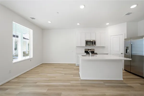 a kitchen with granite countertop a stove a sink and a microwave