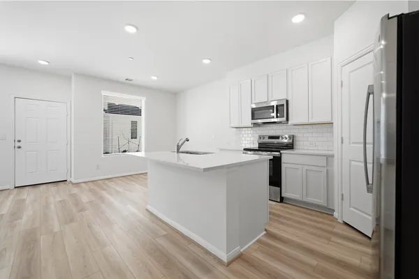 a kitchen with stainless steel appliances a refrigerator sink and microwave
